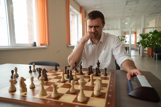 A man switches a chess clock. 