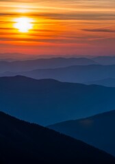 Fototapeta premium Layers of majestic mountains are illuminated by the warm glow of a vibrant sunset in the sky