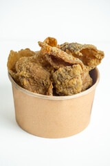 Keripik kulit ayam (Chicken skin chips) in a paper bowl. Indonesian street food.