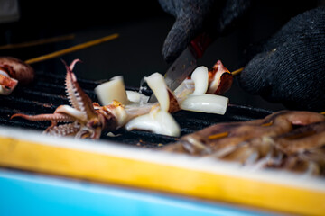 the process of squid being grilled or cooked on a hot plate. Large squid are placed on a heat source