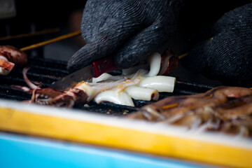 the process of squid being grilled or cooked on a hot plate. Large squid are placed on a heat source
