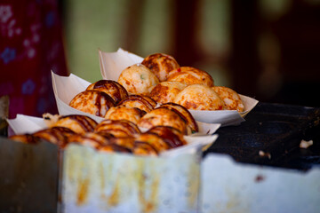  round takoyaki balls are neatly arranged on a plate