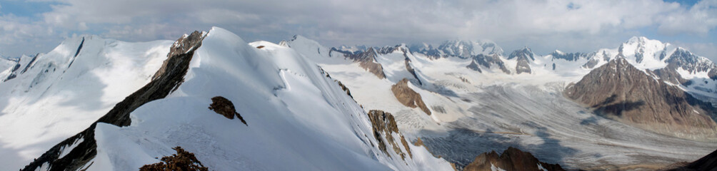 Obraz premium Panorama landscape of high altitude snow mountains of Tian Shan on border of Kyrgyzstan and China. Snow covered summits and valleys with huge glaciers Asia Tian-Shan mountain range extreme expedition