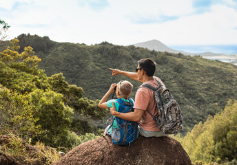 Father son hiking enjoying  breathtaking view of Hawaiian Oahu mountains, family fatherhood travel nature adventure concept 