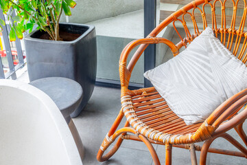 Cozy balcony with rattan chair and potted plant in modern outdoor setting
