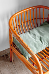 Wooden chair with green cushion on wooden floor in cozy corner