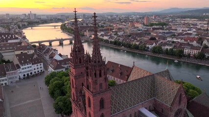 Basel City in Switzerland on Summer Morning. Orange Dawn over the Basler Munster, Church Square and Old town, Aerial.