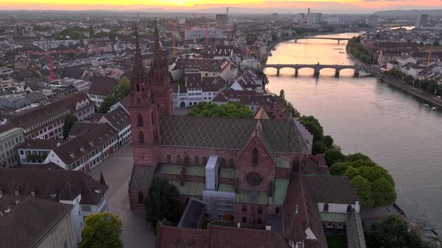 Basel City in Switzerland on Summer Morning. Orange Dawn over the Basler Munster, Church Square and Old town, Aerial.