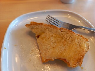 Delicious bitten pieces of cheese bread on a white plate