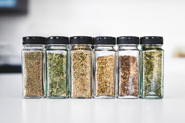 kitchen organization and tidy decanted pantry ingredients, glass jars filled with dried herbs