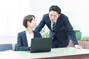 オフィスでパソコンを使って研修を行うビジネスパーソン