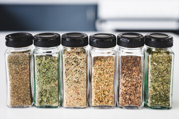 kitchen organization and tidy decanted pantry ingredients, glass jars filled with dried herbs