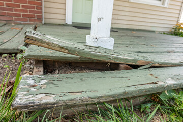 Close up of an extremely warped board on the front porch of a house