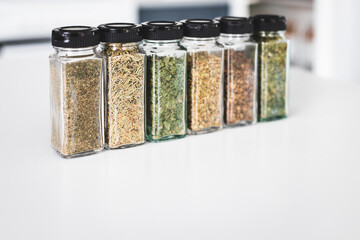 kitchen organization and tidy decanted pantry ingredients, glass jars filled with dried herbs