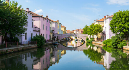 Fototapeta premium Picturesque canal scene showcasing colorful buildings and bridge in Treviso, Italy a serene