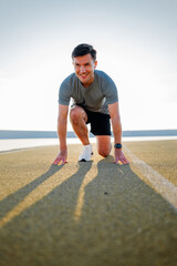 Ready to sprint on a sunlit track in a coastal setting