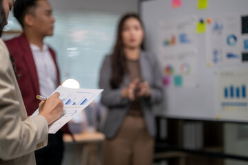 Obraz premium A man is writing on a piece of paper in front of a white board