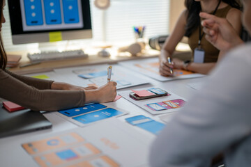 A group of people are sitting around a table with a white board and a laptop