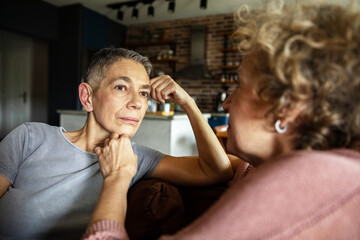 Mature lesbian couple having a deep emotional conversation together at home