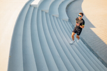 Man runs up stairs in urban setting for fitness and enjoyment