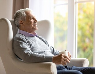 A medium shot of an elderly man sitting in a comfortable armchair by a window, a soft, contented smile on his face as he watches his grandchildren play in the garden