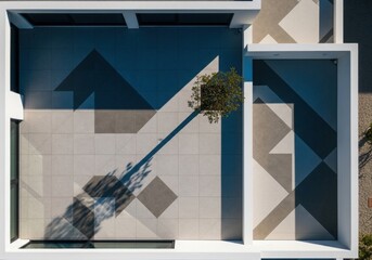 Geometric courtyard with modern tile patterns and a single tree casting a long shadow.