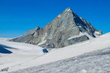 Obraz premium Alps mountains snow ridges view of Monte Rosa massive. Lyskamm, Pollux and Castor summits above the clouds stunning landscape mountains view. Alps high attitude extreme terrain climbing and glacier