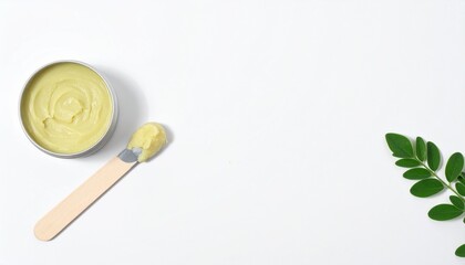 Luxurious natural balm in tin with spatula and green leaf, pure skincare beauty.