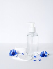 Pure skincare essence with calming blue cornflowers and soft cotton pads