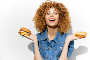 Happy young woman with curly hair showcasing delicious burgers, embodying joy and healthy eating in a vibrant photo shoot with a modern vibe