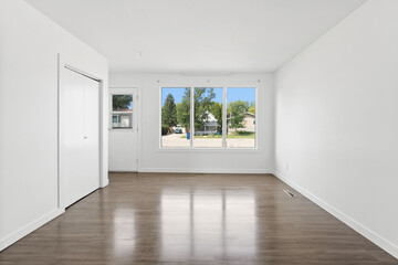 Large, empty room with a window and a door
