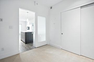 White room with a kitchen and a door