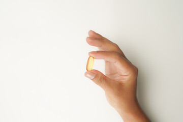 Male hand holding soft gels, Fish oil capsules, omega 3, omega 9, vitamin D, vitamin E, supplements