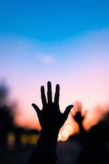 Silhouetted hands reaching towards a stunning sunset, evoking freedom, hope, and connection