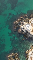 Seascape from Above: A serene aerial perspective reveals the mesmerizing interplay of clear turquoise waters meeting the rugged shoreline. Monopoli, Puglia