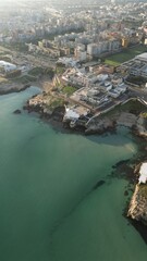 Coastal City Panorama: An aerial view of a coastal city reveals a vibrant landscape where urban structures meet the tranquil expanse of the sea, creating a sense of harmony. 