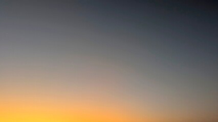 A beautiful gradient sky, transitioning from dark blue to vibrant orange and yellow, with a subtle star or planet visible, capturing the essence of dawn.