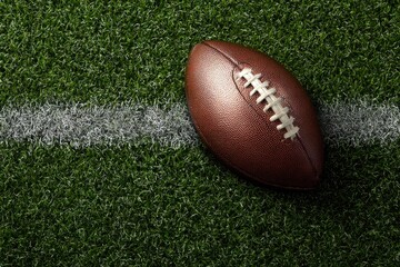 Obraz premium American football resting on a field, near a white line