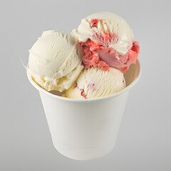 A paper cup filled with scoops of vanilla and strawberry 