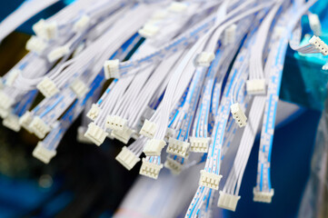 Manufacturing process focuses on electric wires and connectors in a workshop setting during daytime...