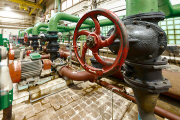 Industrial water pump system with valves and motors in a factory setting during daylight hours