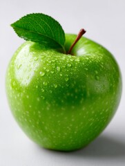 A green apple with a leaf on top of it