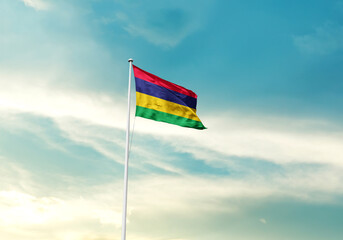 Mauritius flag is waving on a tall flagpole among the clouds. Mauritius national flag for...