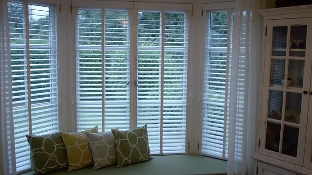 Bright Bay Window with White Shutters Green Cushion And Pillows Decorative Cabinet