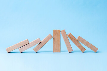 A Single Wooden Block Stands Upright, Stopping A Domino Chain Reaction From Continuing