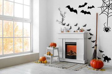 Interior of living room decorated for Halloween with fireplace, pumpkins and paper bats