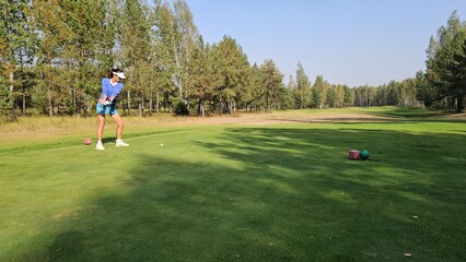 Golfer preparing to swing on a sunny day at a serene green course