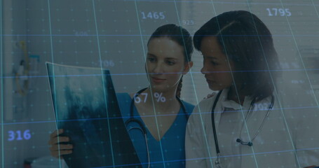 Two doctors in scrubs and lab coat studying X-ray film in clinic, with digital data overlay