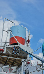 Colorful water tank on industrial structure against blue sky with clouds near coastal area concept