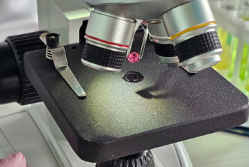 Detailed view of a microscope examining a gemstone specimen in a laboratory